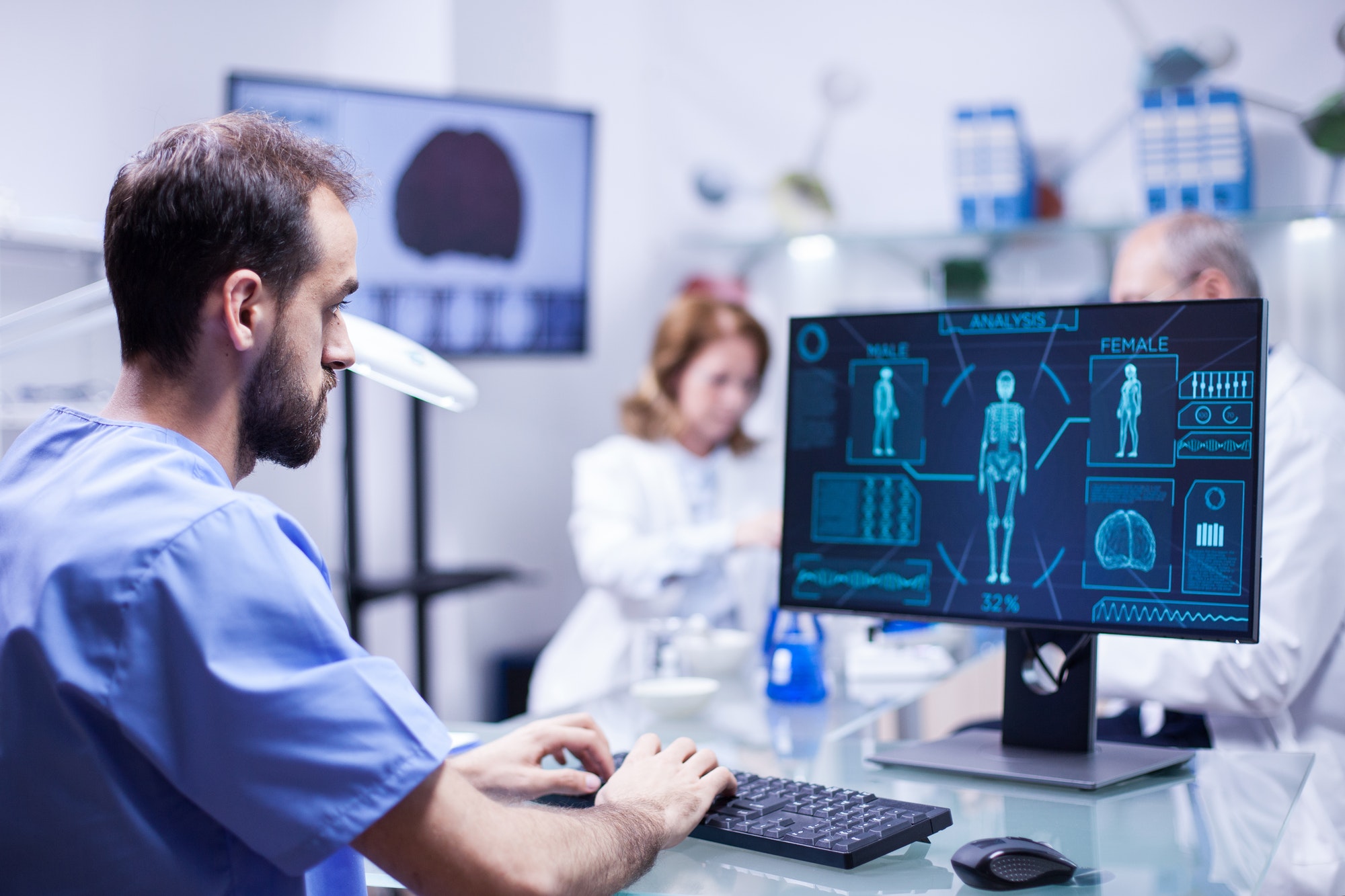 Young technician typing data for human body neurology system in science laboratory